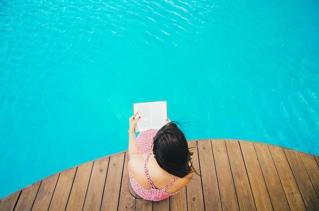 Booktok Sommer Romane: Frau liest Buch am Pool