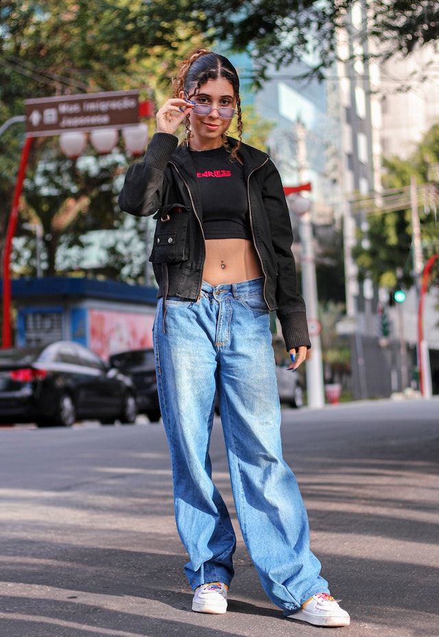 Frau posiert in Baggy-Jeans auf der Straße