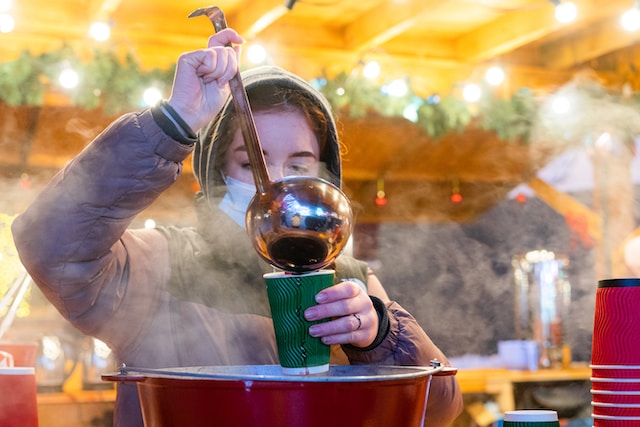 Frau schenkt Glühwein ein